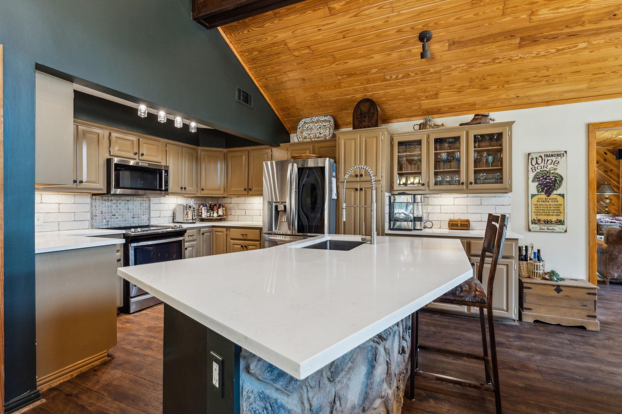 Gourmet kitchen with quartz island and stainless steel appliances